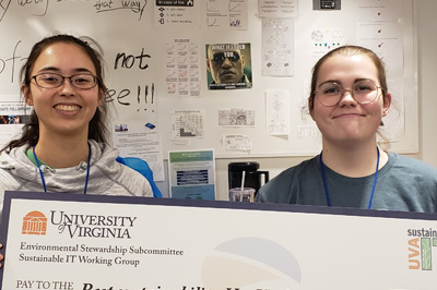 Electrical engineering majors Emily Flynn and Colleen Foley hold an oversized check for 500 dollars, their prize from U.V.A. Sustainable I.T. for best HooHacks project